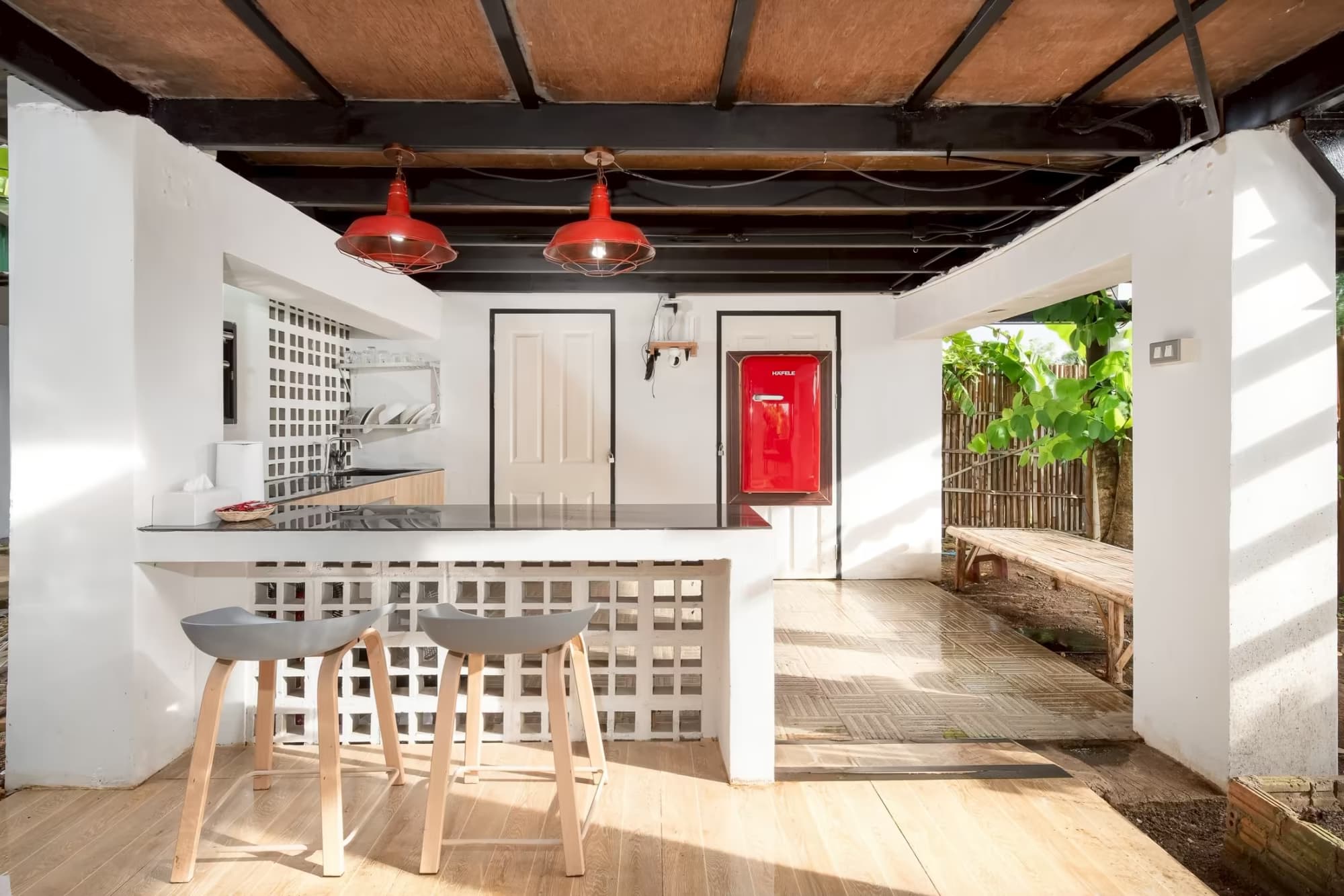365 Vila Connect Pai breakfast bar with red pendant lights, bar stools and retro red fridge opening to the garden