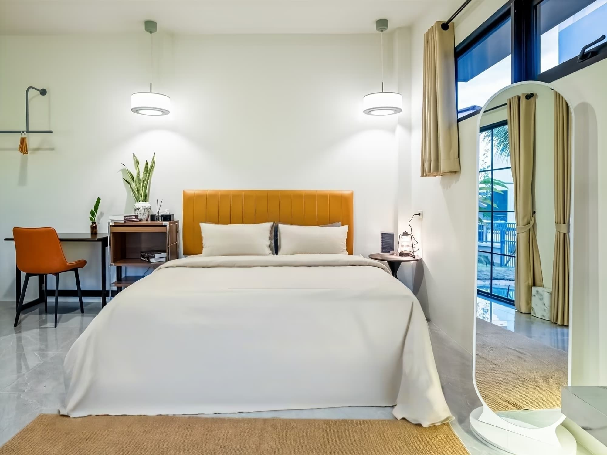 The Arch Casa Pai Suite with Mountain View bedroom with tan leather headboard, full-length mirror and garden-facing window