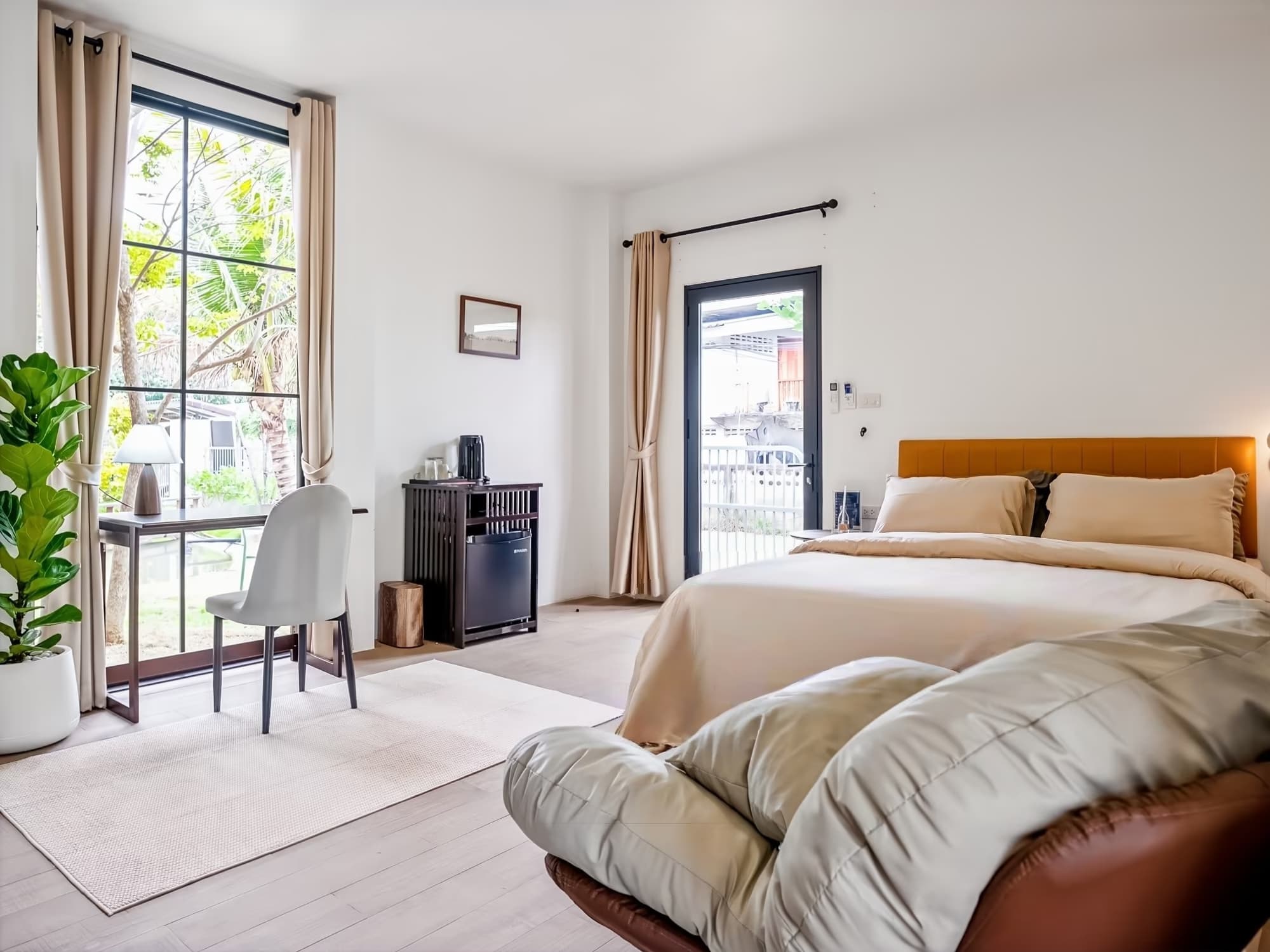 The Arch Casa Pai Suite with Garden View, bright bedroom with floor-to-ceiling windows, leather headboard and garden access