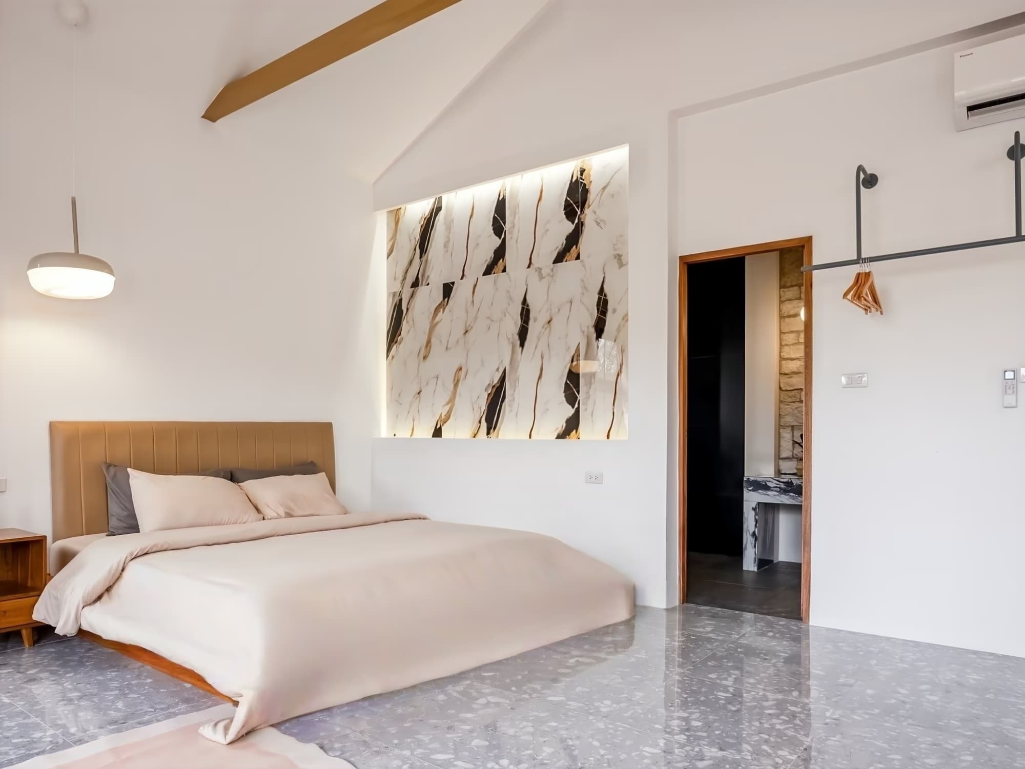 The Arch Casa Pai Studio with Mountain View bedroom with marble feature wall, vaulted ceiling and king bed on terrazzo floor