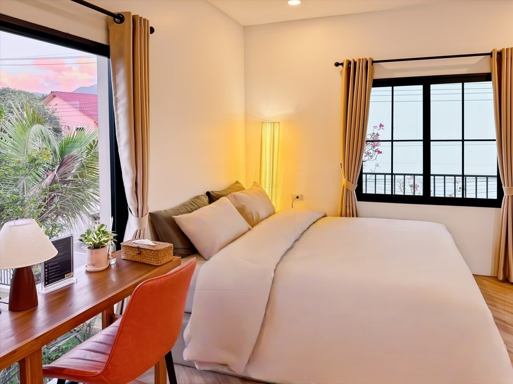 The Arch Casa Pai Studio with Terrace queen bed at golden hour with sunset mountain view and orange leather chair