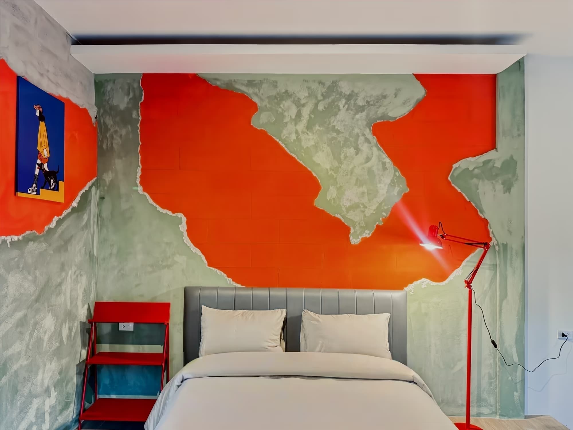 The Arch Casa Pai Deluxe King Studio bedroom with bold orange and sage art mural, king bed and red designer floor lamp