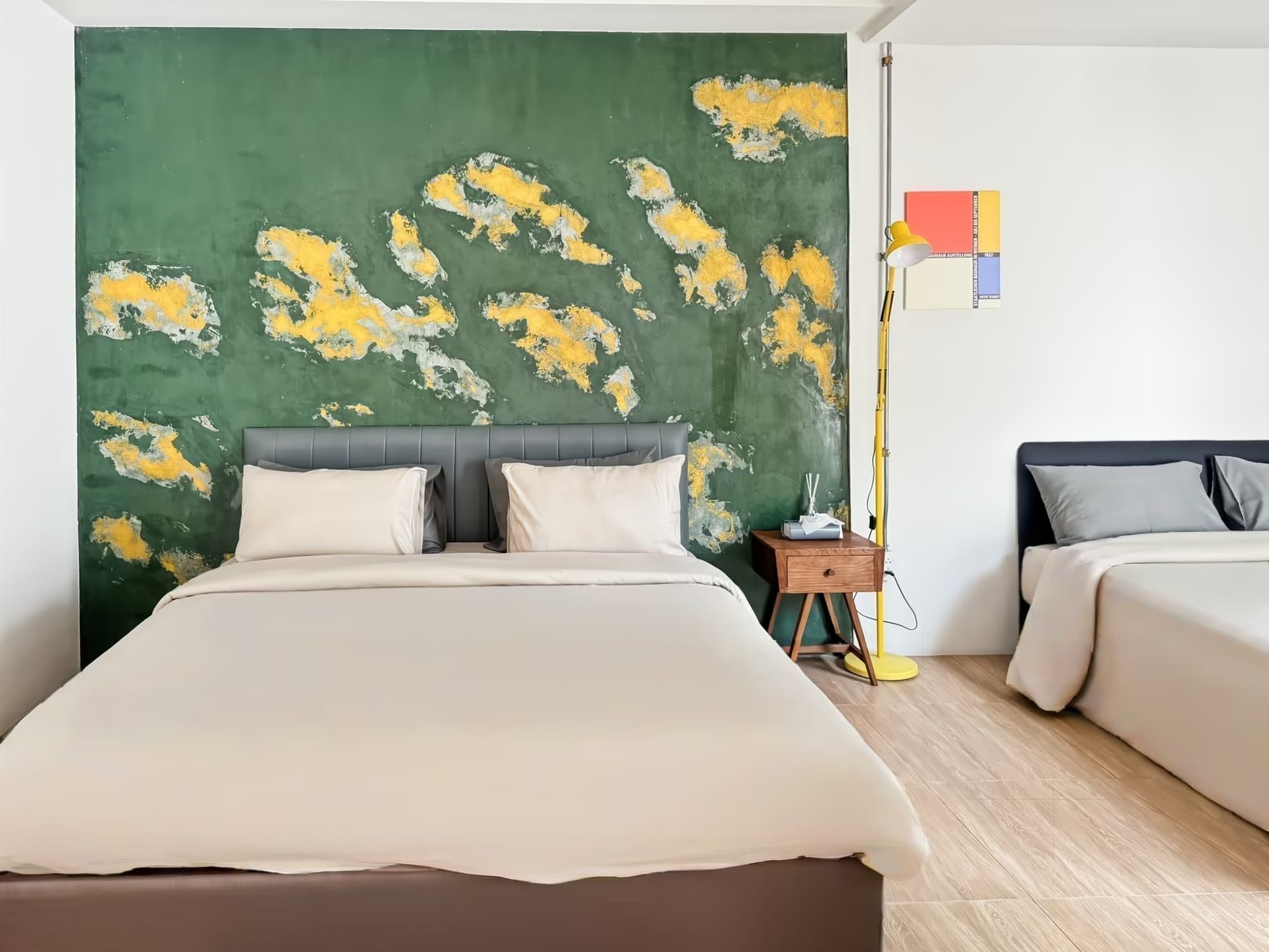 The Arch Casa Pai Classic Quadruple Room with signature green and yellow textured art wall, king bed and second bed, sleeps four