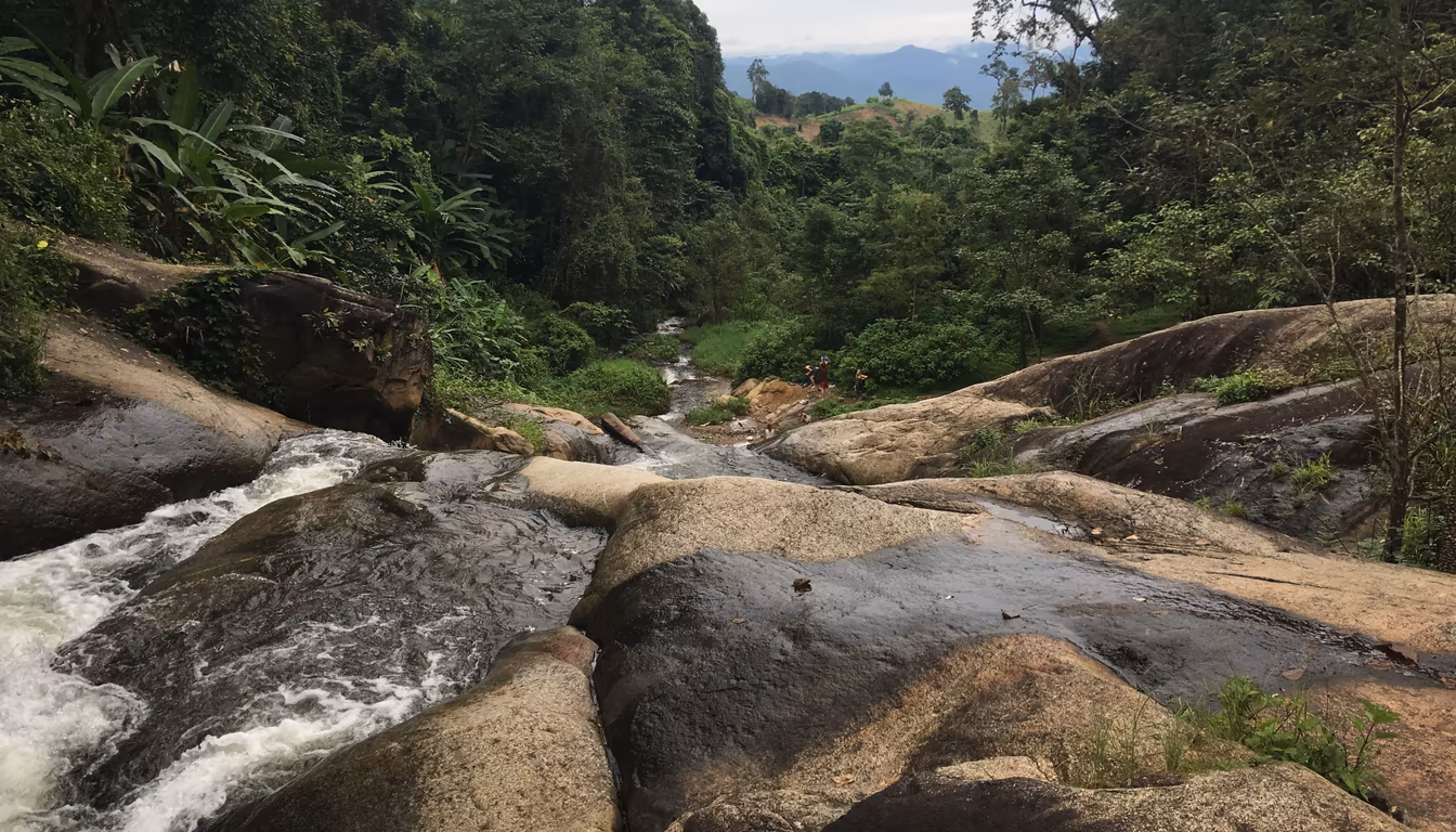 Mo Paeng Waterfall running full in green-season Pai in June with smooth rock tiers
