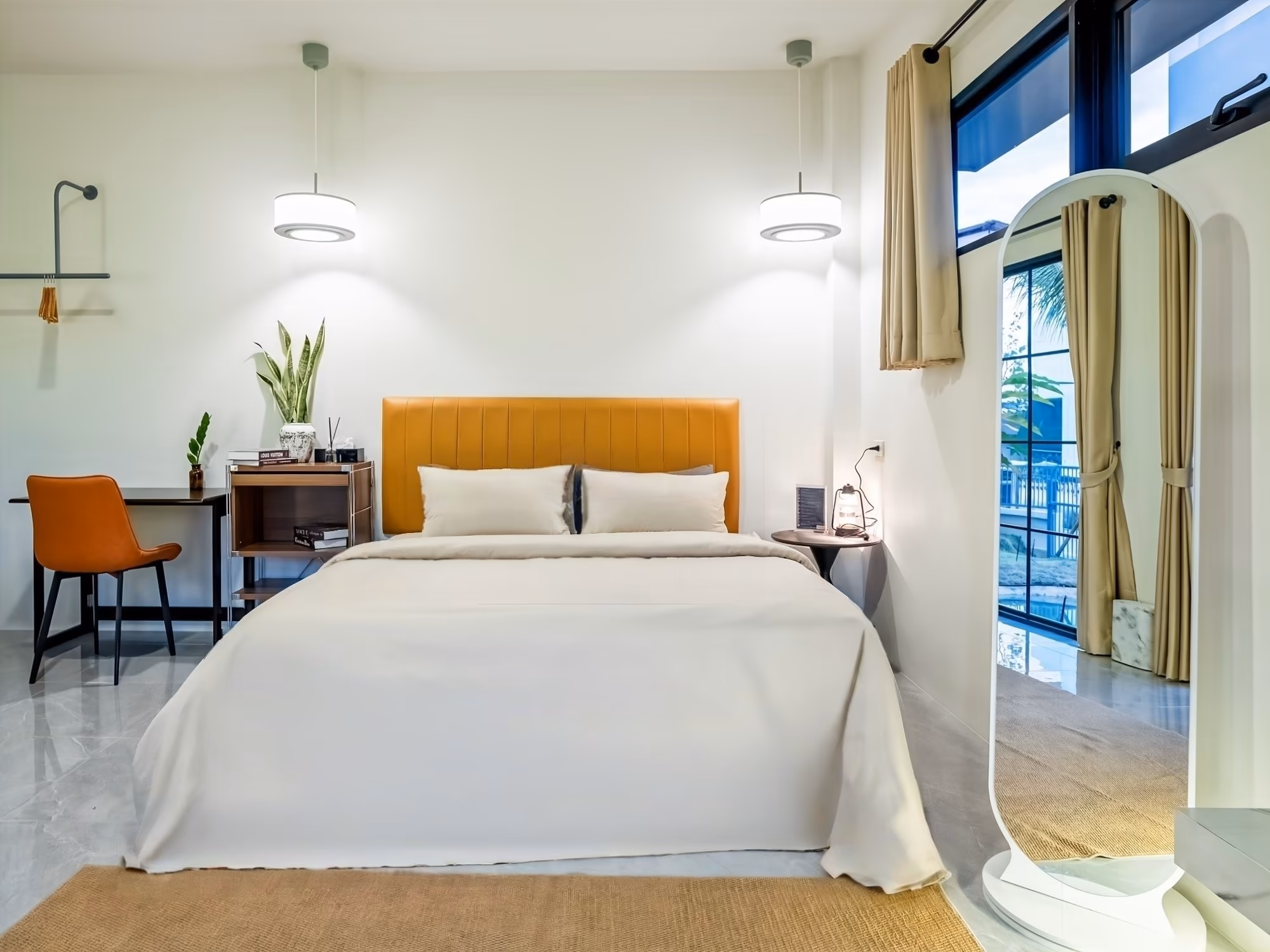 The Arch Casa Pai Suite with Mountain View bedroom with tan leather headboard, full-length mirror and garden-facing window