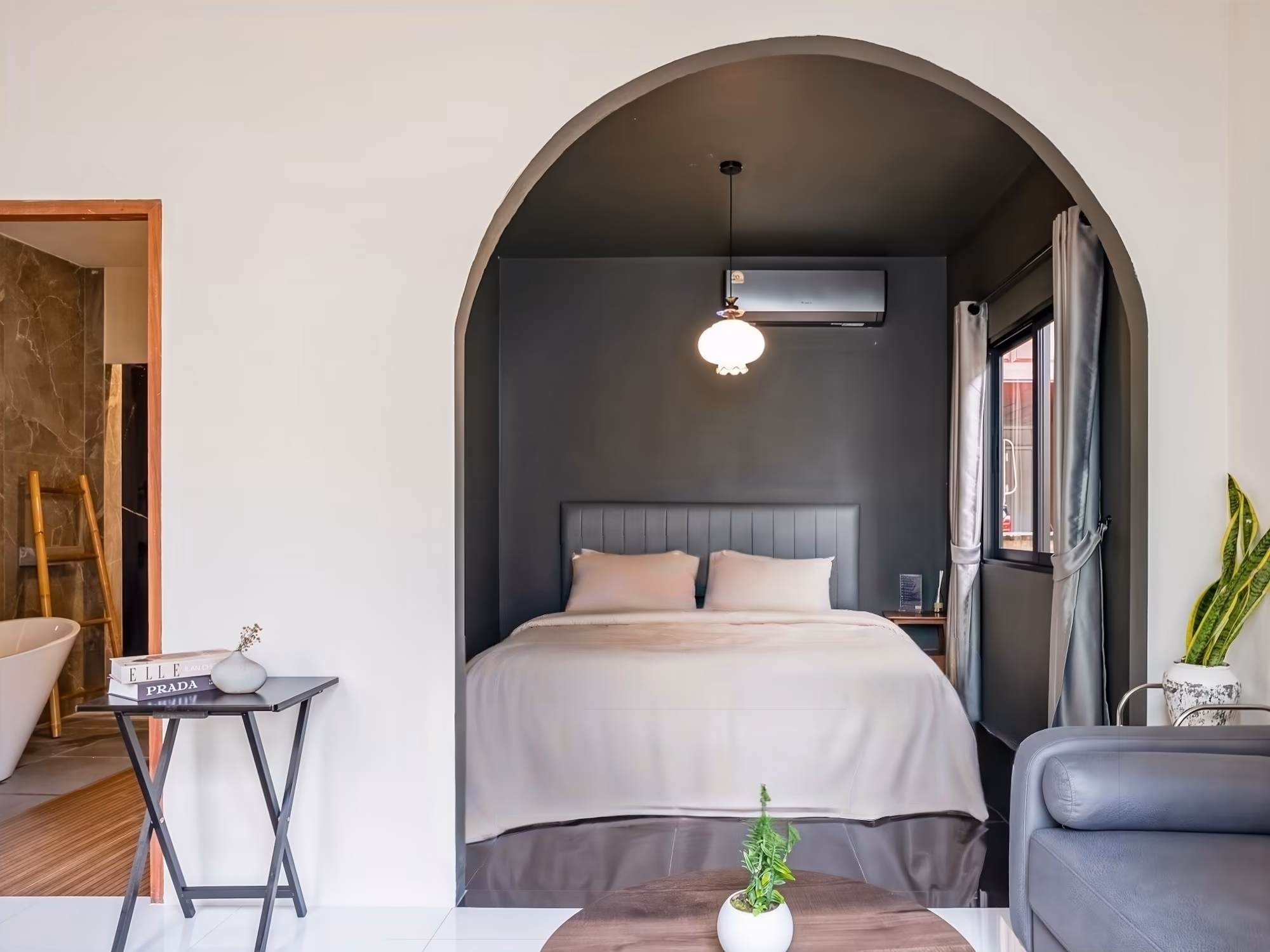 The Arch Casa Pai Deluxe Double Room with Bath, arched alcove bedroom with charcoal feature wall, pendant light and open bathtub view