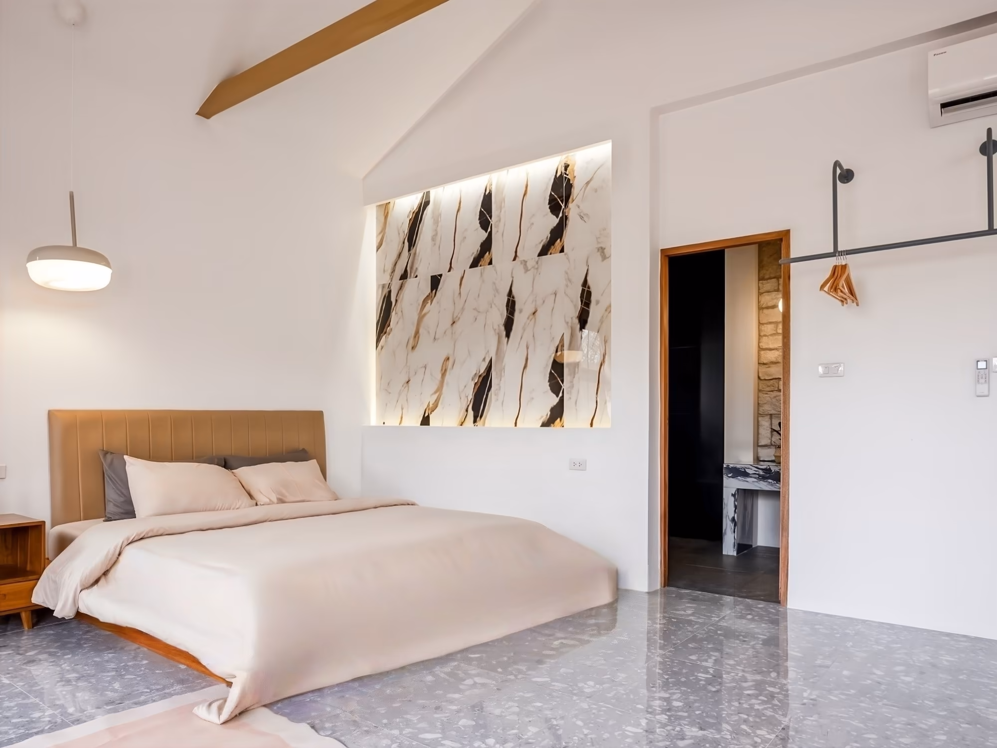 The Arch Casa Pai Studio with Mountain View bedroom with marble feature wall, vaulted ceiling and king bed on terrazzo floor