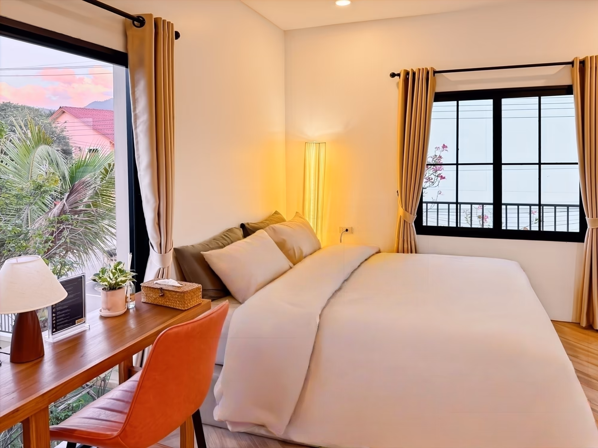The Arch Casa Pai Studio with Terrace queen bed at golden hour with sunset mountain view and orange leather chair