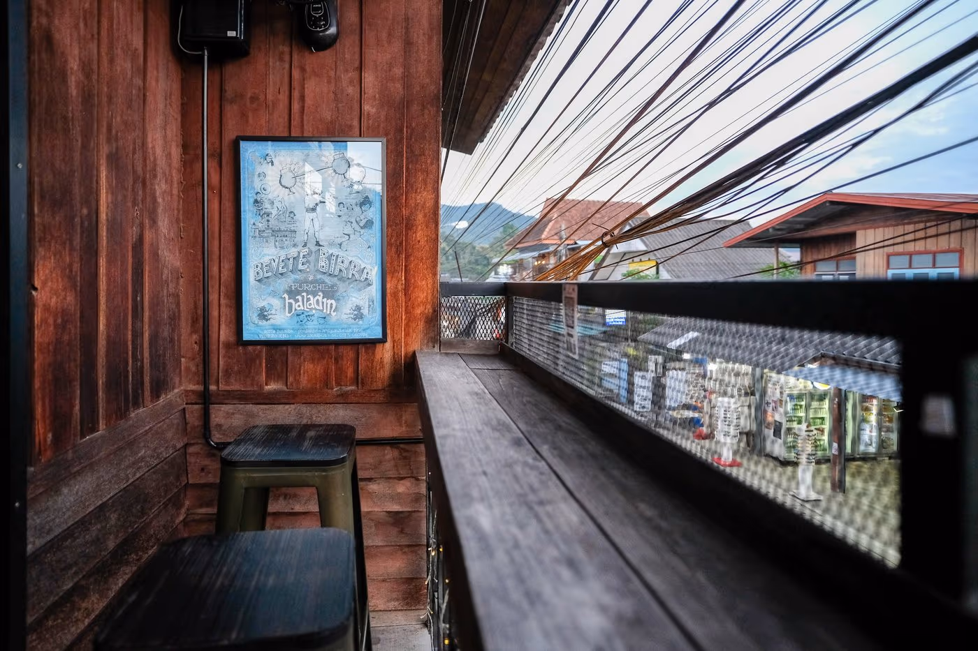 The balcony over Pai Walking Street at Vermut Café — a bar table looking down on the market