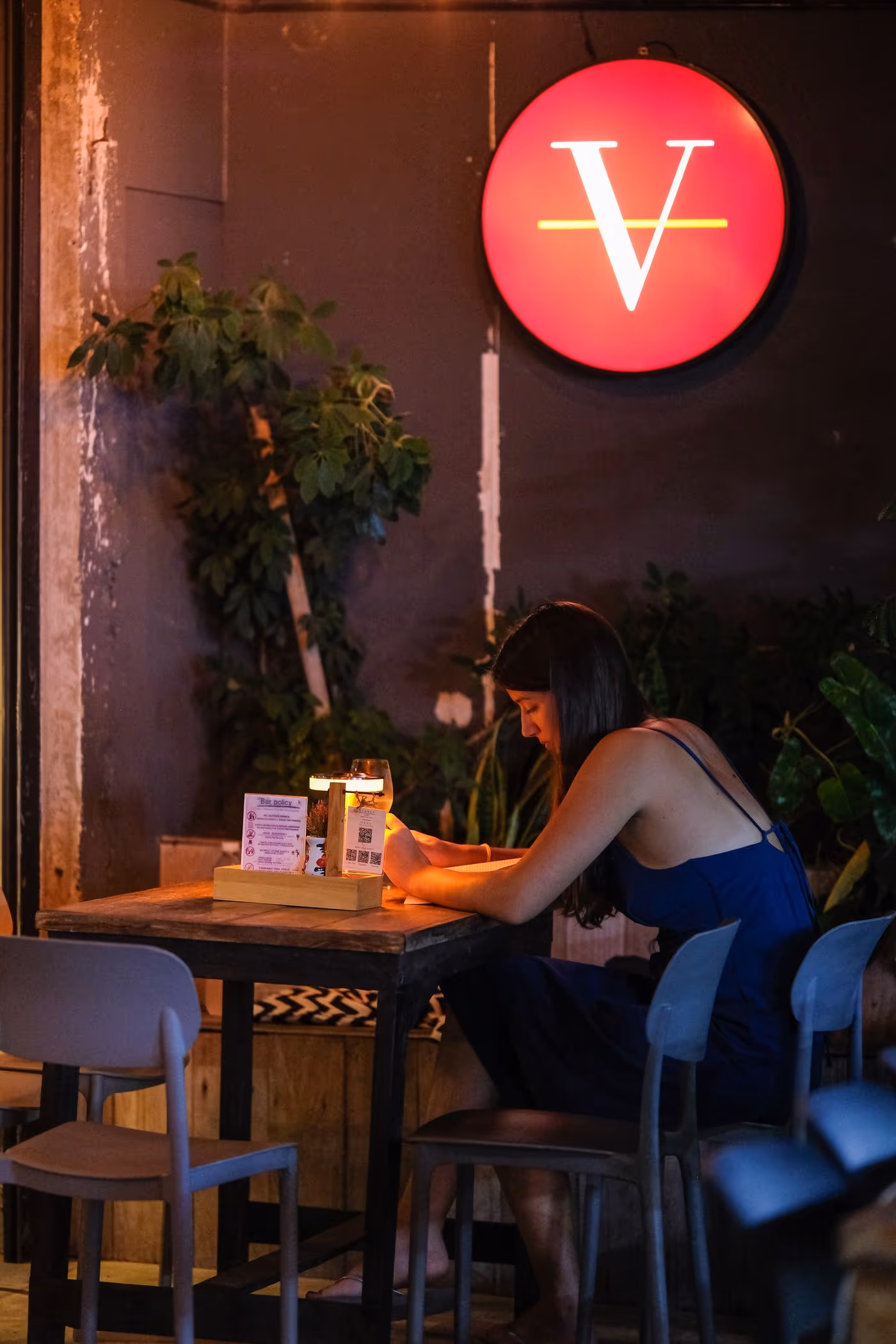 The quiet corner at Vermut Café, Pai — a single lamp-lit table under the red V sign