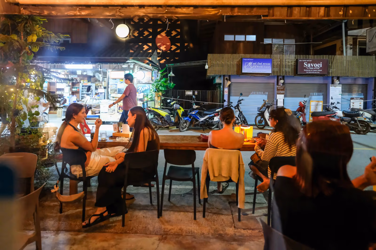 Friends at the front tables of Vermut Café, seen from Pai Walking Street in the evening