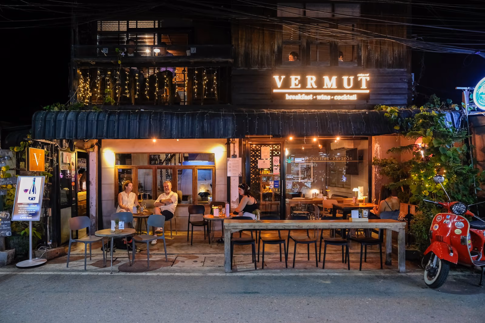 Vermut Café seen from Pai Walking Street at night — the VERMUT sign, the open front and the long table outside
