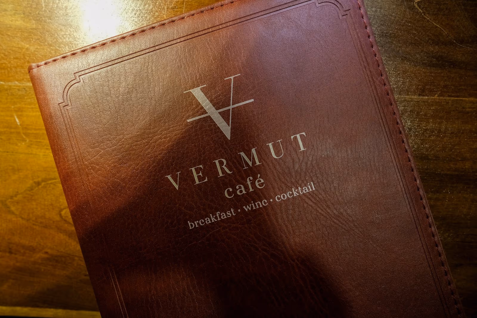 The Vermut Café menu bound in leather — breakfast, wine, cocktail — on the table in Pai