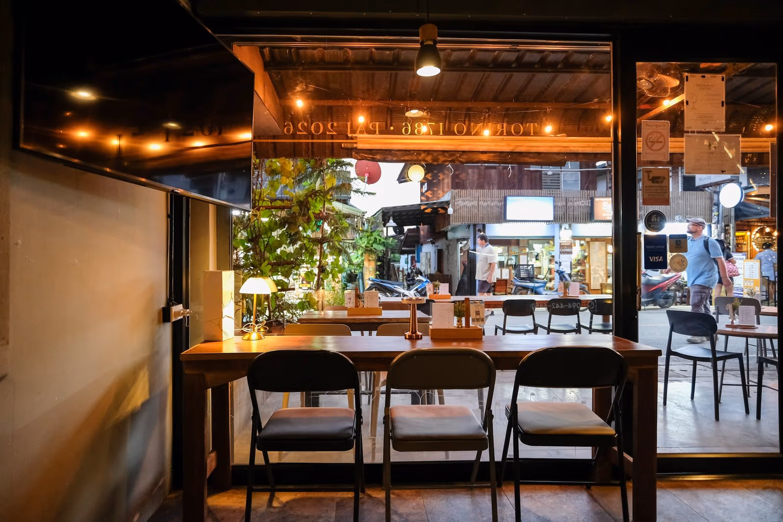 The long table out front at Vermut Café, Pai Walking Street, set under the lamps in the early evening