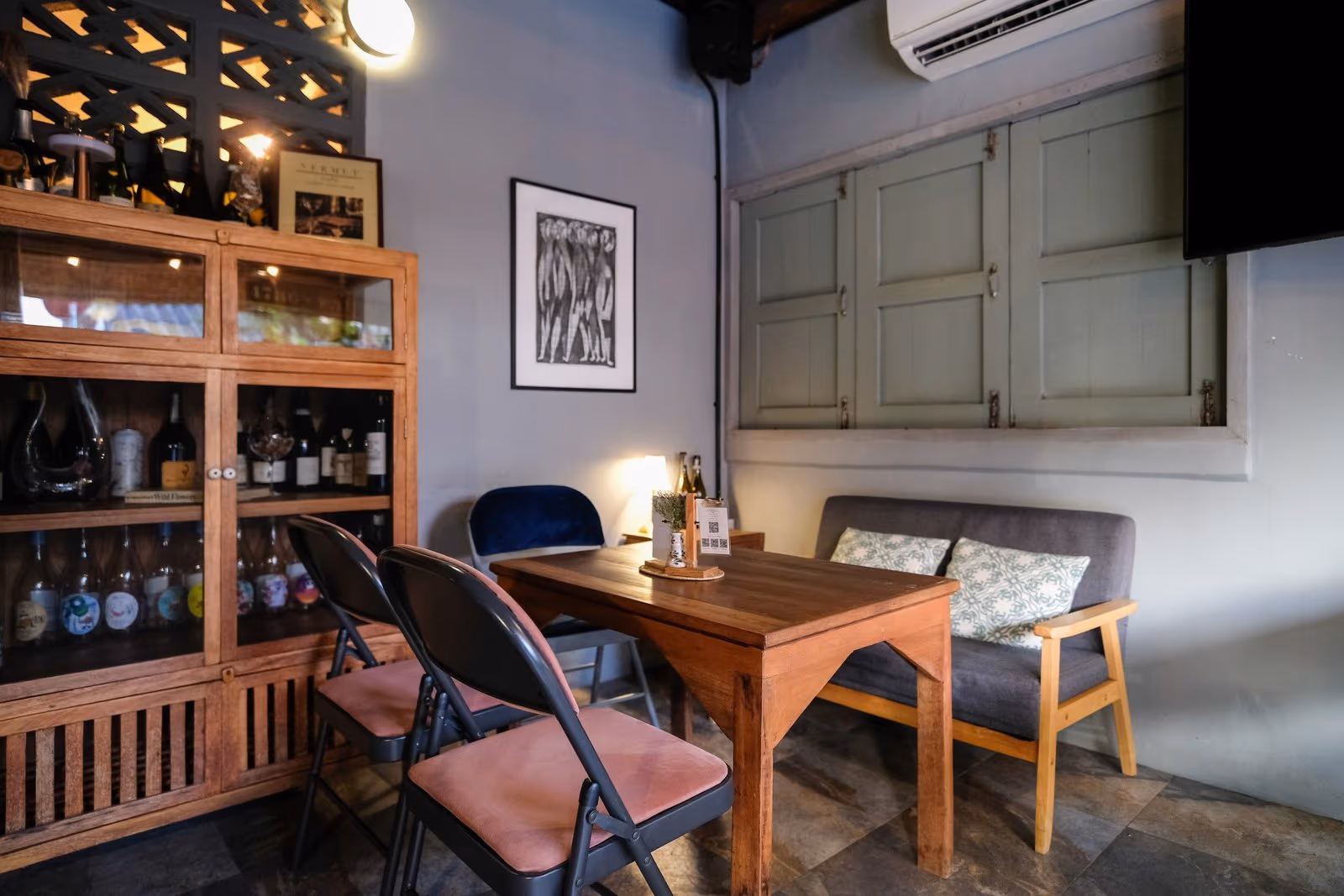 The reading corner at Vermut Café, Pai — a wooden table by the shelves in the upstairs room