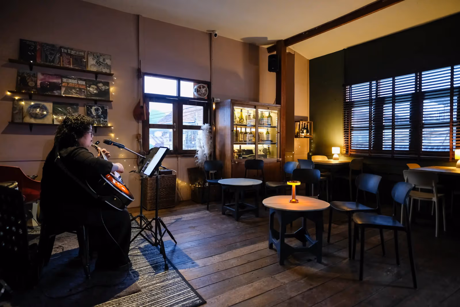 The air-conditioned upstairs lounge at Vermut Café, Pai — round tables, lamps and the record shelf
