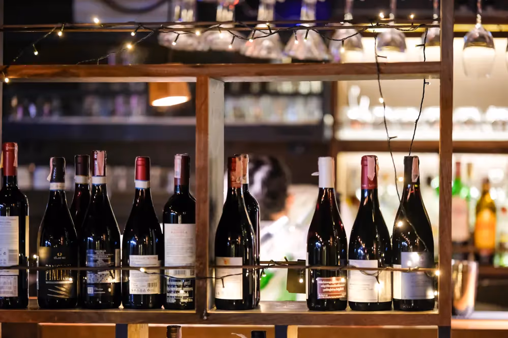 Rows of red wine on the back shelf at Vermut Café, Pai — around 60 wines, all by the glass